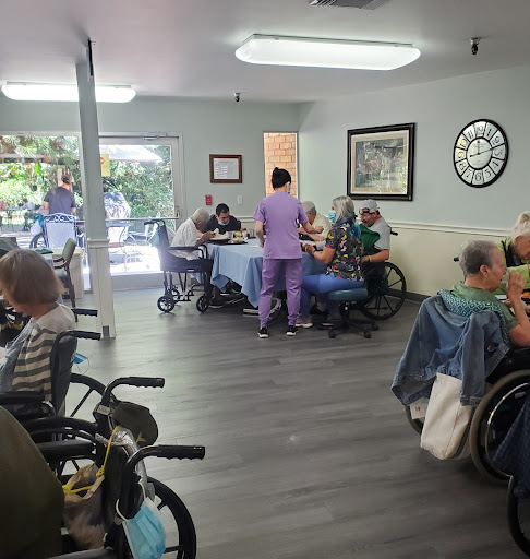 A vibrant community setting in a nursing home where staff engage with residents during an activity.