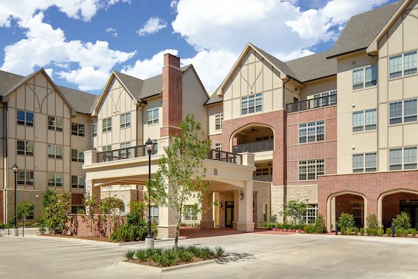 A modern residential apartment building with a mix of brick and stucco exterior.