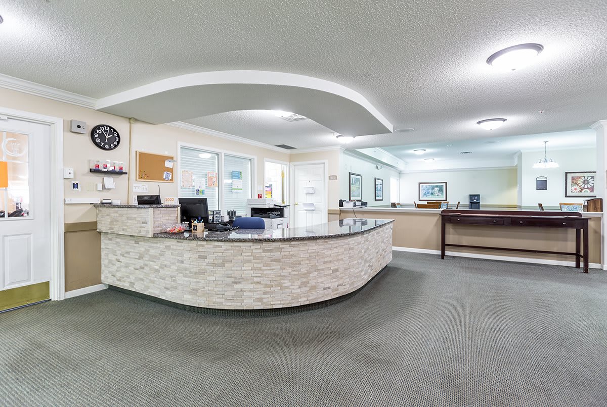 A modern reception area with a curved desk and office amenities.