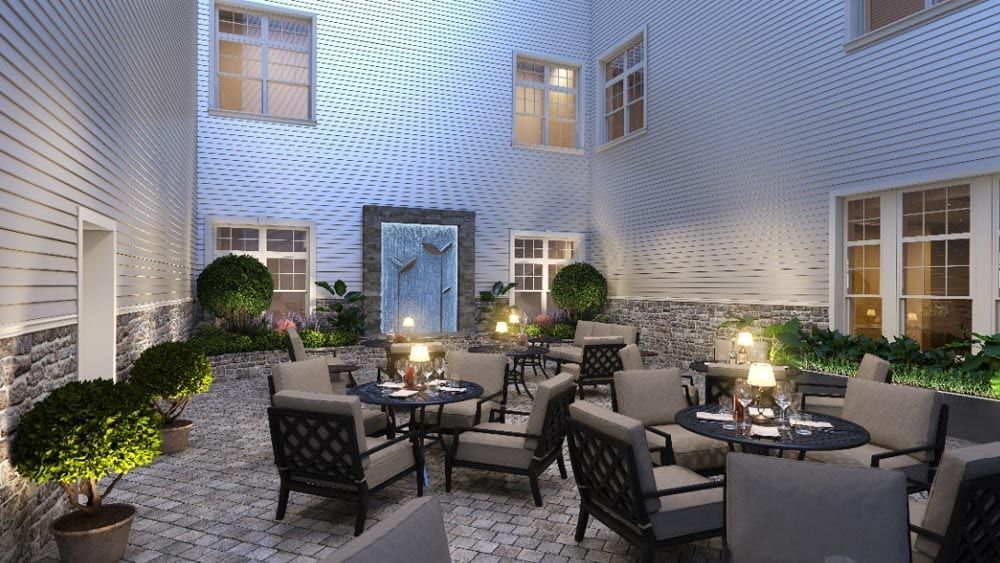 A cozy courtyard with elegant outdoor seating and soft lighting, perfect for a relaxing evening.