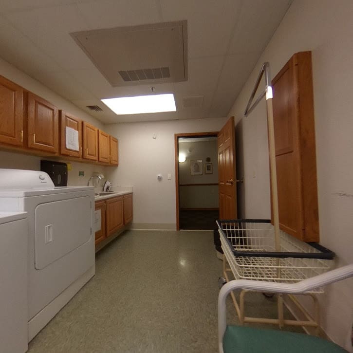 A well-organized laundry room with wooden cabinets and a washer-dryer set.