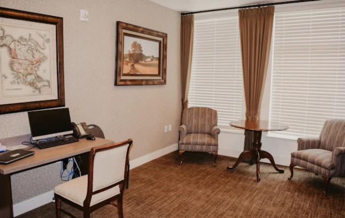 Cozy office space with a desk, chair, and window with curtains.