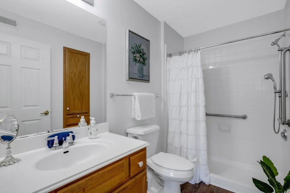 A clean and modern bathroom with a sink, toilet, and shower area.