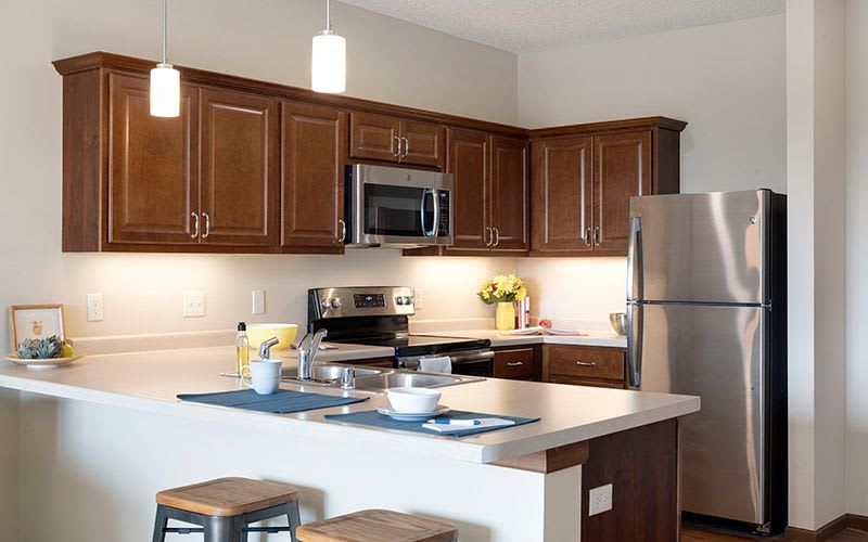 A modern kitchen with wooden cabinets and stainless steel appliances.