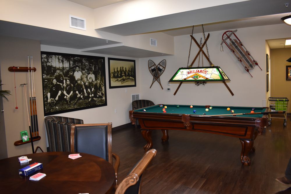 A cozy game room featuring a pool table, vintage sports decor, and comfortable seating.