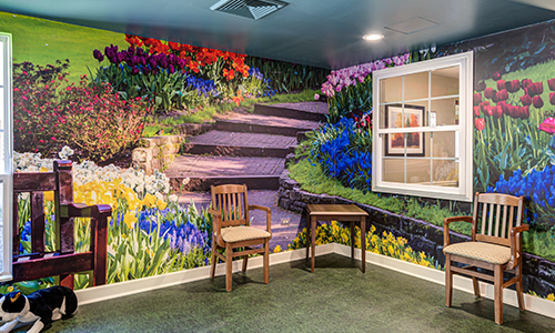 A vibrant mural of a garden scene with colorful flowers and stairs enhances the room's interior design.