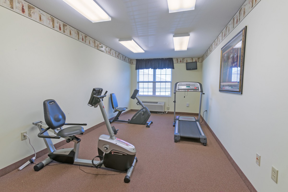A small gym with exercise equipment including a treadmill and stationary bike.