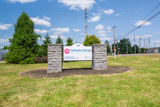 A welcoming sign for a community named 'Catawba Springs' set against a clear blue sky.