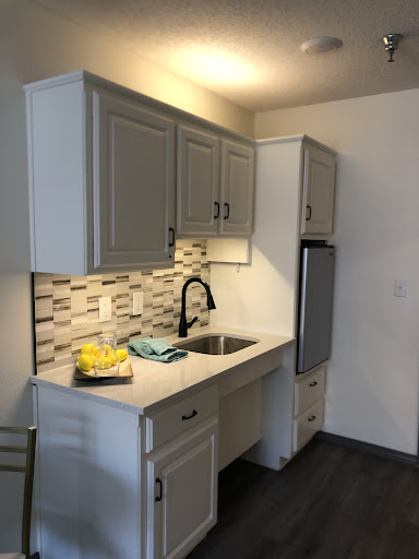 A modern kitchen featuring grey cabinets, a stylish sink, and contemporary appliances.