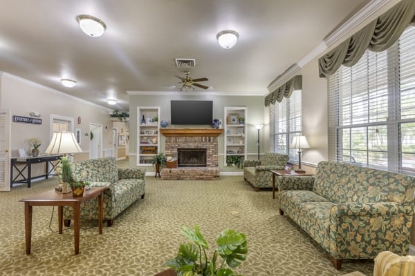 A cozy living room with a fireplace, sofas, and bookshelves.