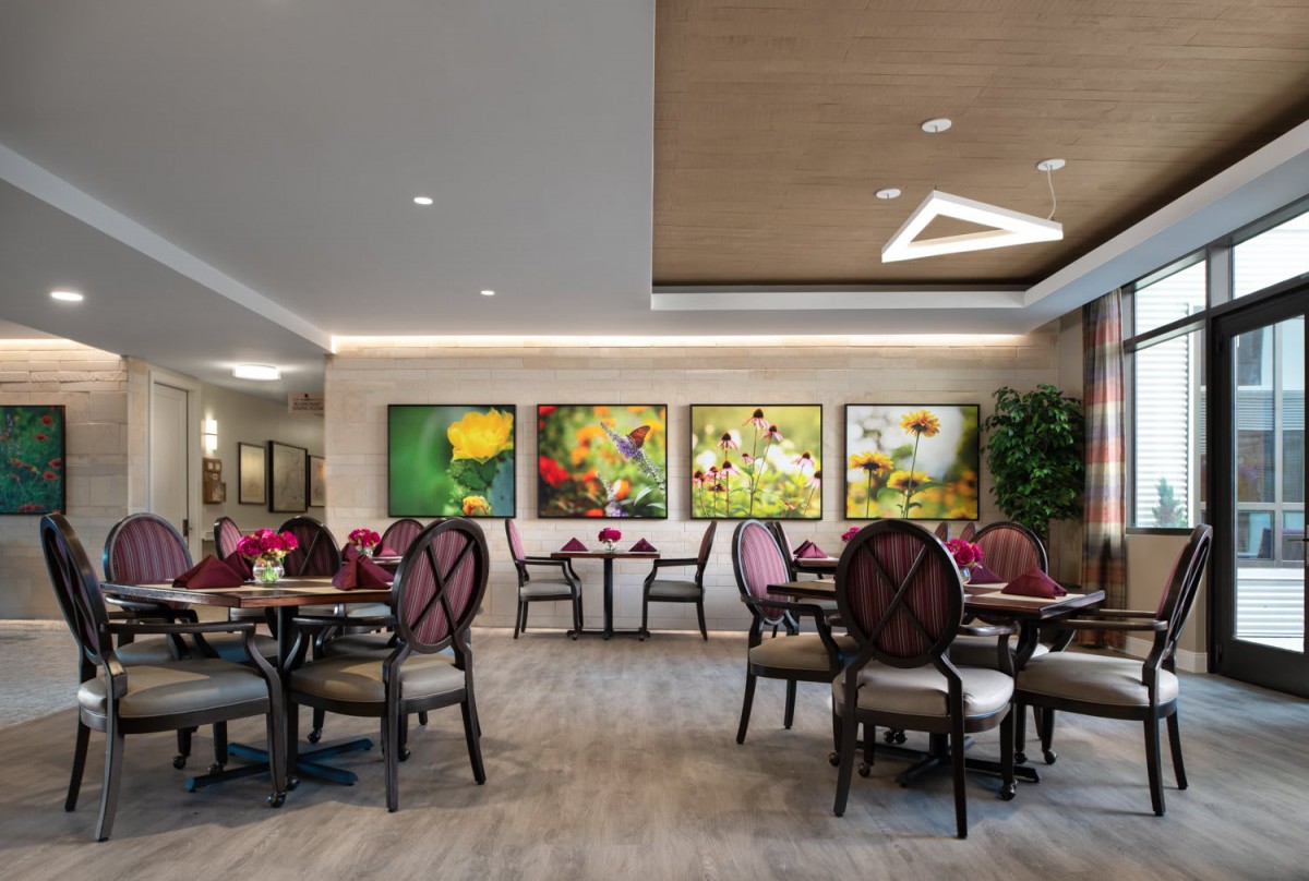 A modern restaurant dining area featuring elegant furniture and colorful artwork on the walls.