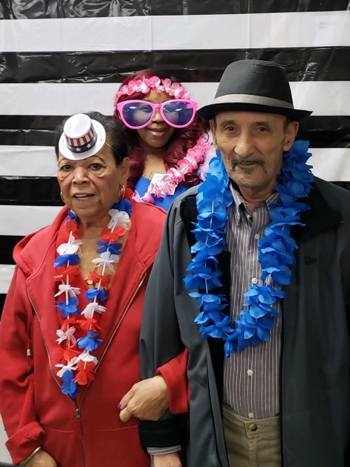 A group of people dressed up with leis, hats, and fun accessories at a celebration.