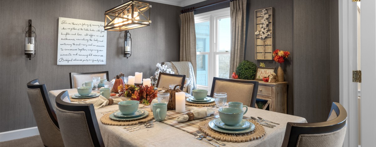 A beautifully decorated dining table with candles and fall-themed decor.