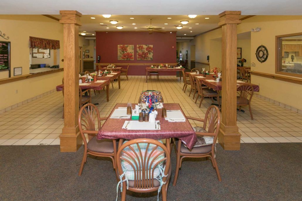 A cozy dining area with neatly set tables and warm lighting.