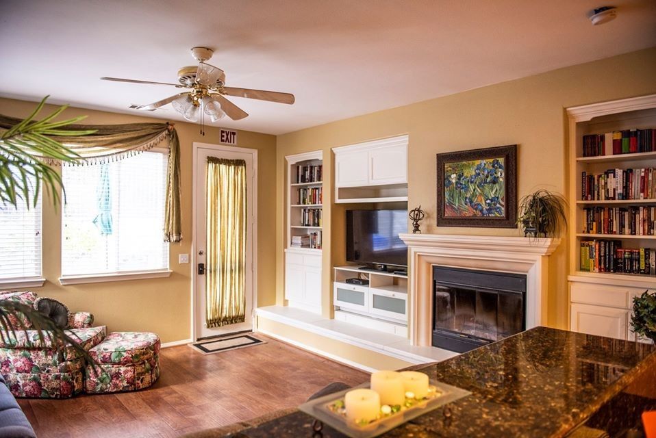 Cozy living room with fireplace and ceiling fan.