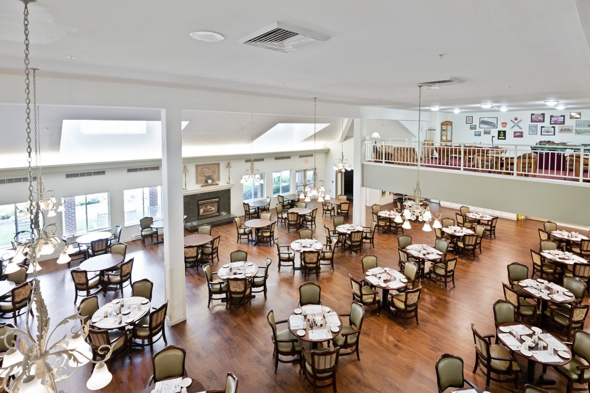 Spacious dining hall with wooden floors and neatly arranged tables.