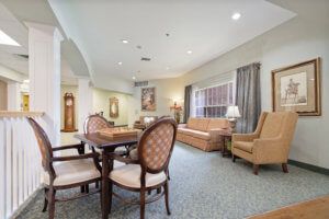 A well-furnished living room with a seating area and table, featuring elegant decor.