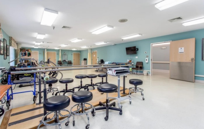 A spacious physical therapy clinic equipped with therapy stools and exercise equipment.