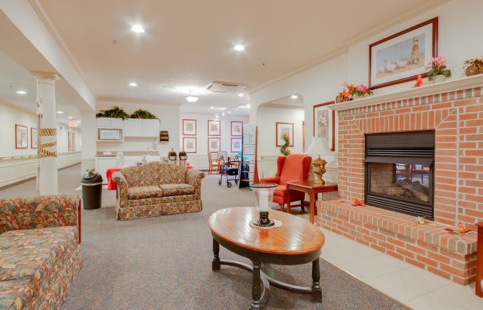 A cozy living room featuring a sofa, armchairs, a coffee table, and a fireplace.