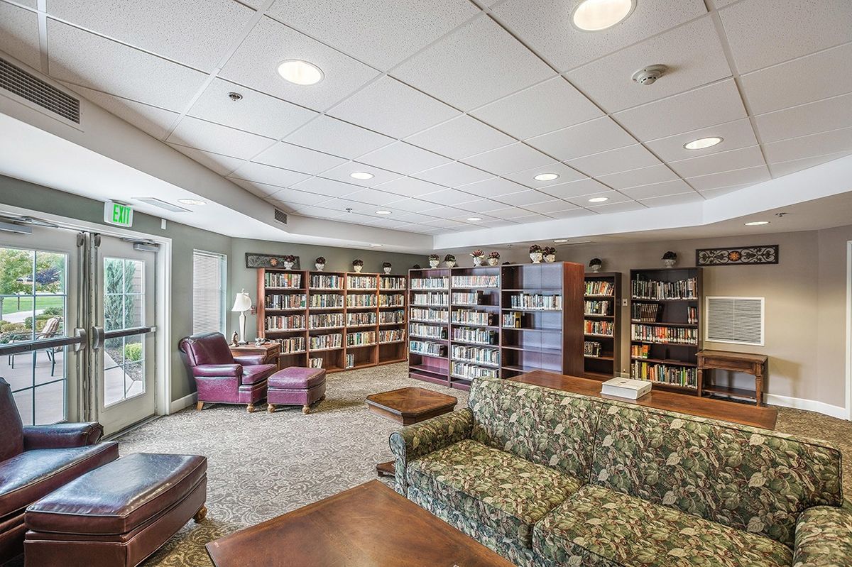 A cozy library reading room with bookshelves and comfortable seating.