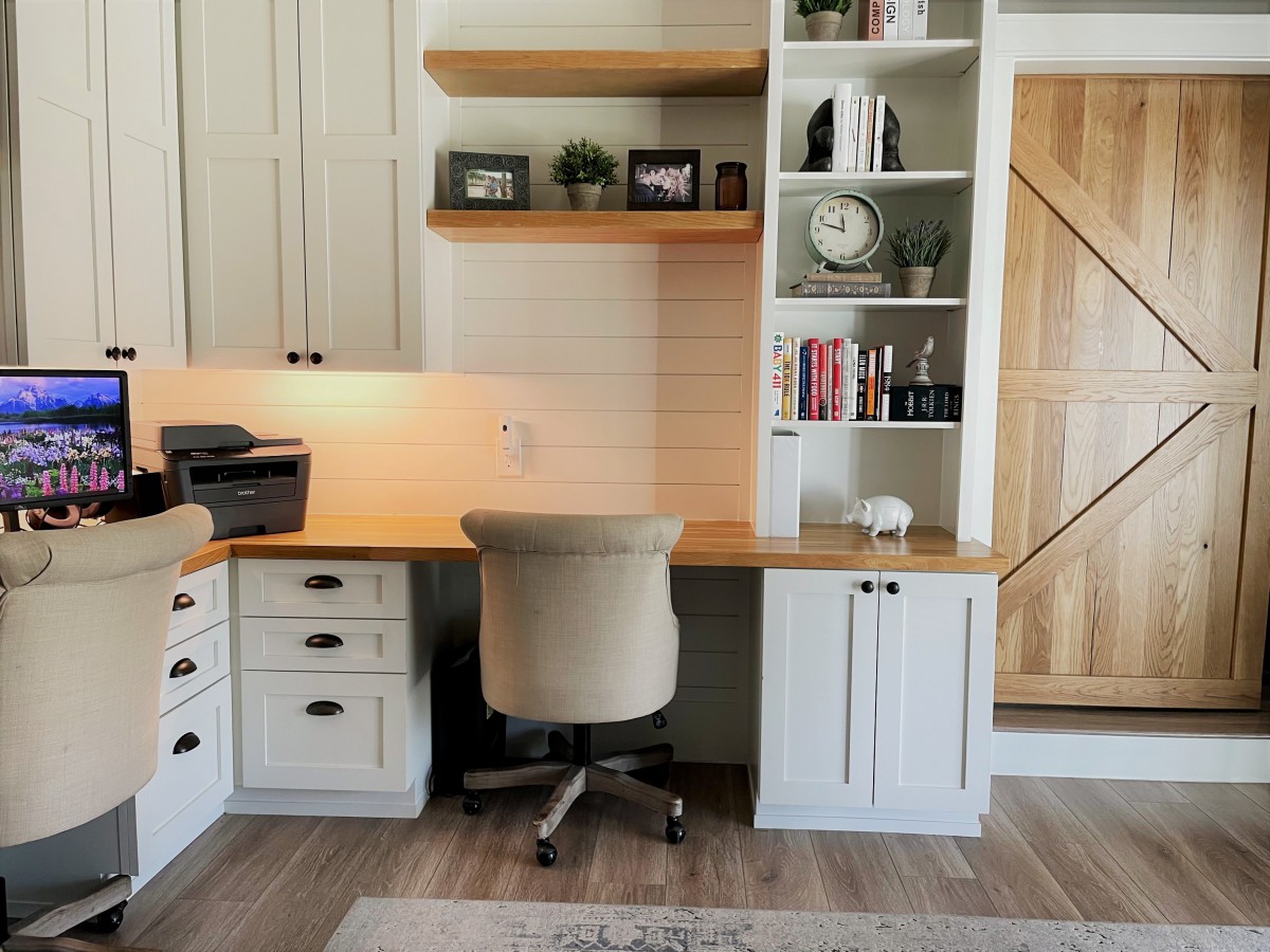 A well-organized home office space with a desk, chair, shelves, books, and decor.