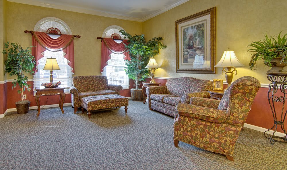 A cozy living room with patterned sofas, armchairs, a coffee table, and decorative elements.