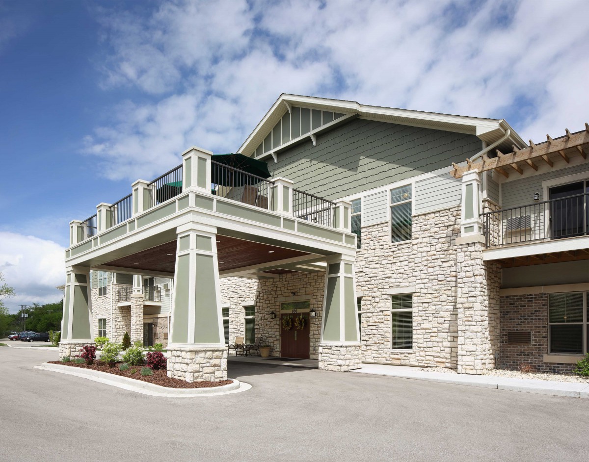 A modern building with stone exterior and a covered entrance.