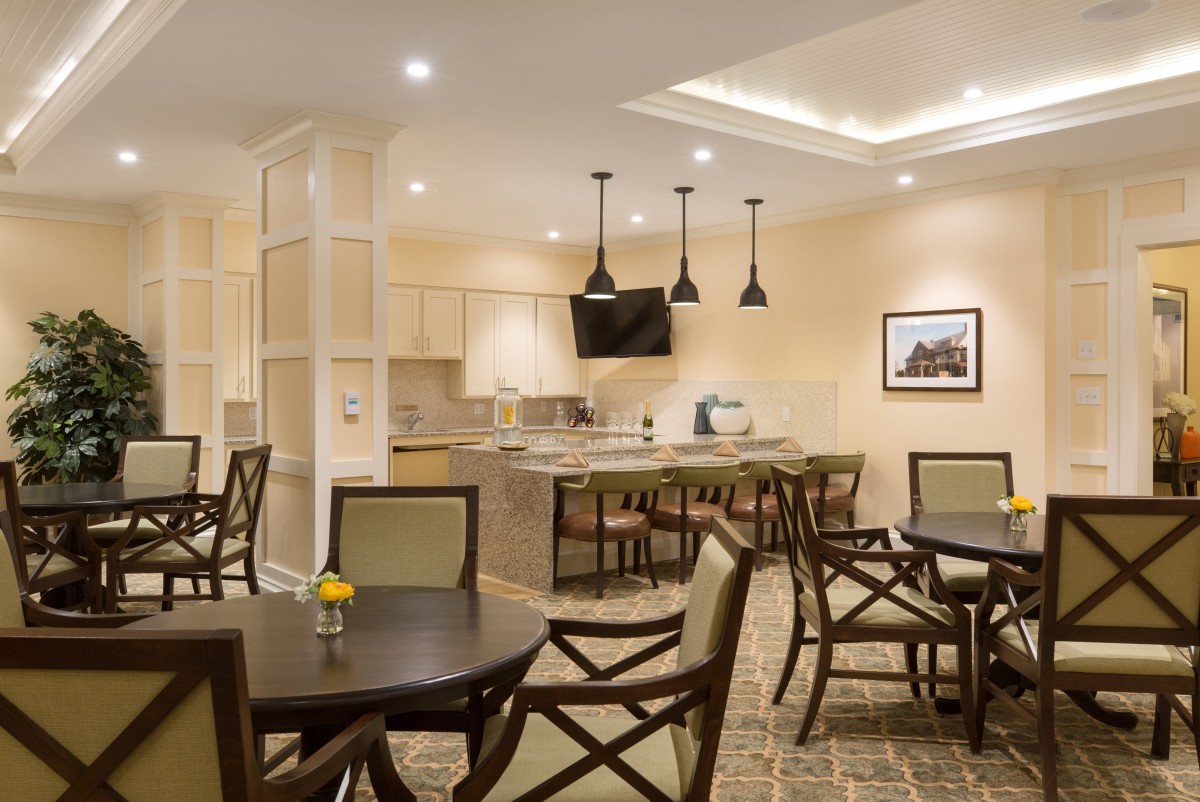 A modern dining area with neatly arranged tables and chairs, complemented by elegant lighting fixtures.