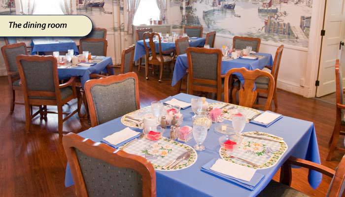 A cozy restaurant interior with tables set for dining and adorned with blue tablecloths.