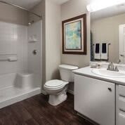 A clean, modern bathroom with a shower, toilet, and sink.