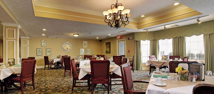A cozy dining room with elegantly set tables and a chandelier.
