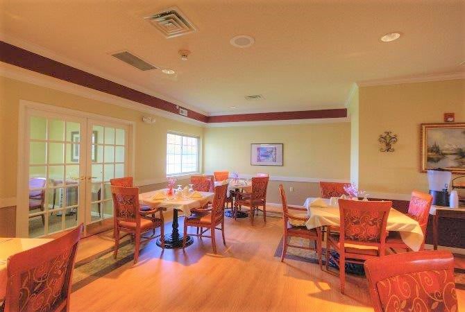 An empty dining room with neatly arranged tables and chairs.