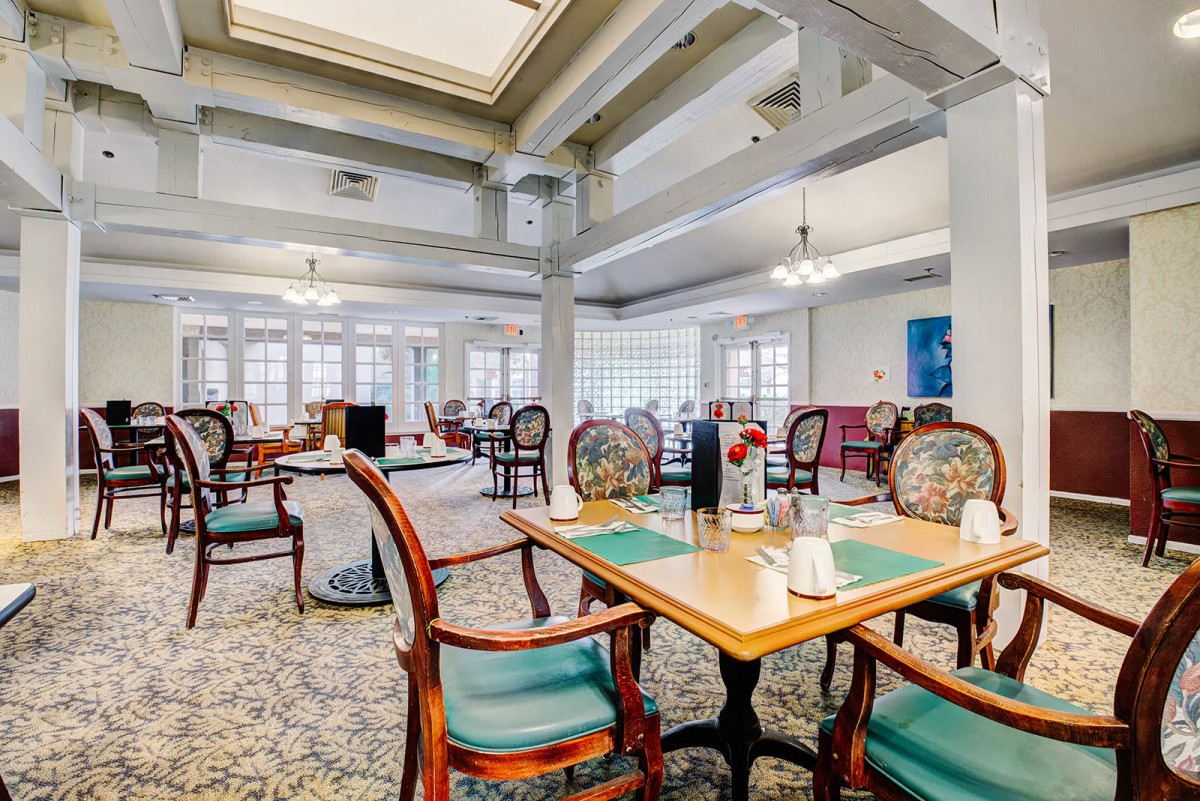 An elegant dining area with classic decor, featuring tables set for guests.