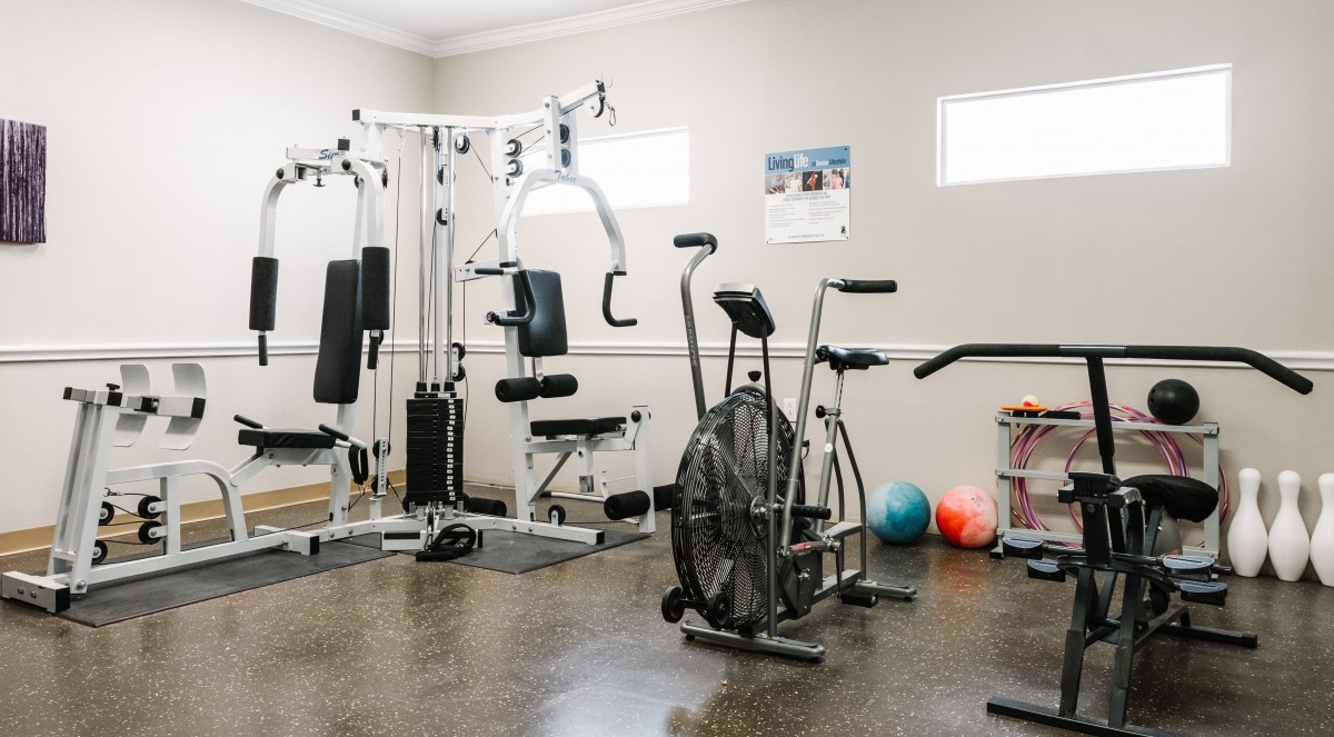 A well-equipped indoor gym with various exercise machines and fitness equipment.