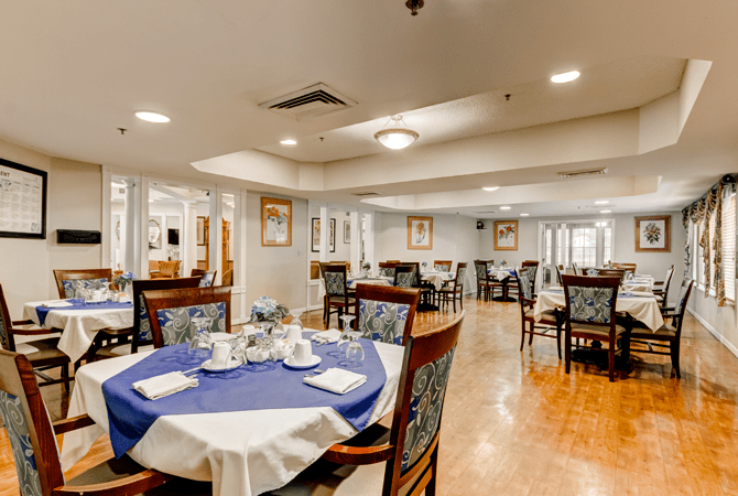 A spacious dining room with elegantly set tables and comfortable seating.