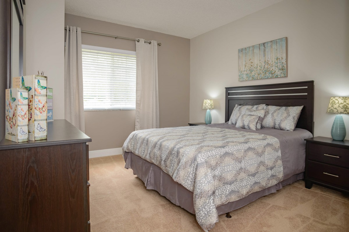A cozy bedroom with a neatly made bed, soft lighting, and modern decor.