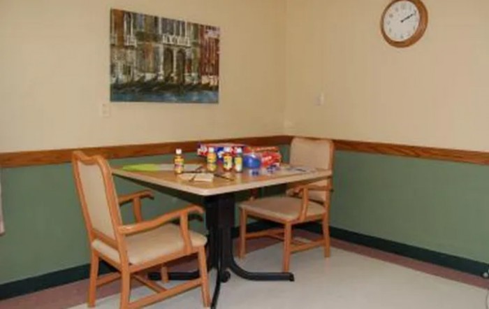 A small room with a table and two chairs, displaying snacks and drinks.