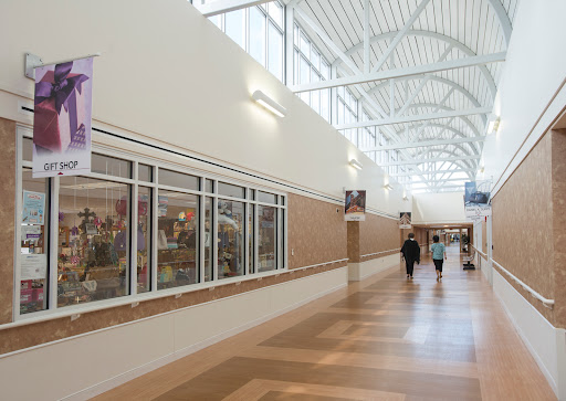A well-lit interior hallway featuring decorative banners and people walking through a commercial space.