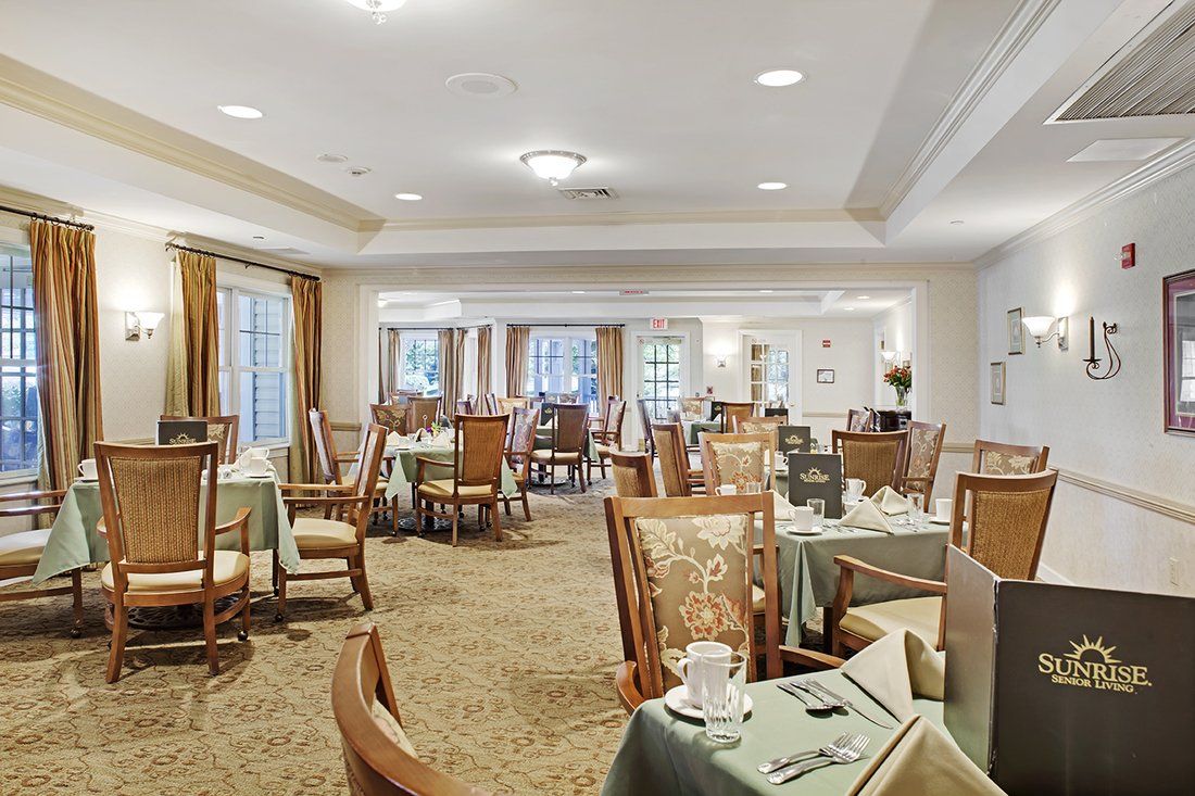 A well-lit dining area with neatly arranged tables and chairs, adorned with elegant table settings.