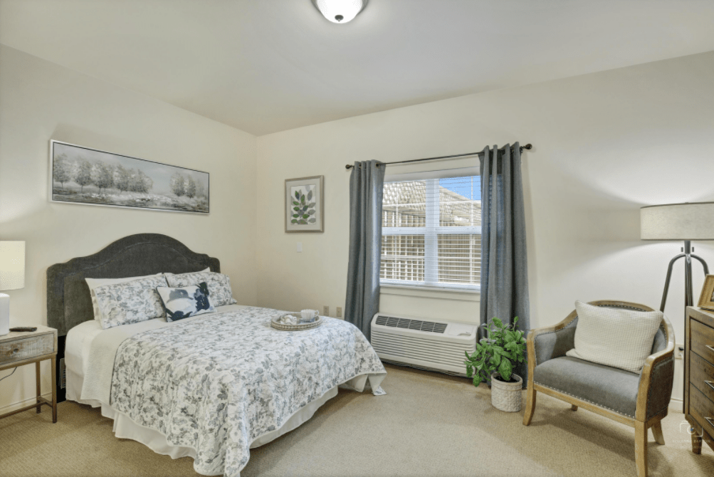 A cozy bedroom with a comfortable bed, a window with curtains, and charming decor.