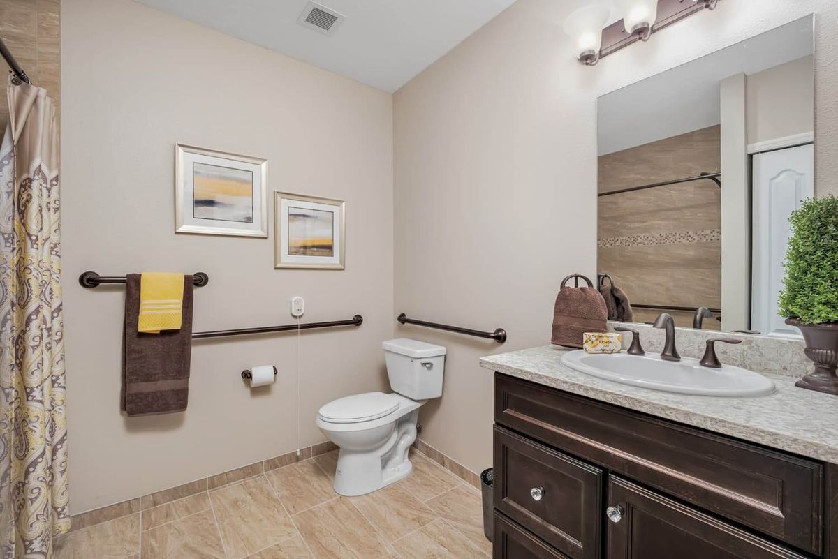 A modern bathroom with a toilet, sink, and decorative elements.