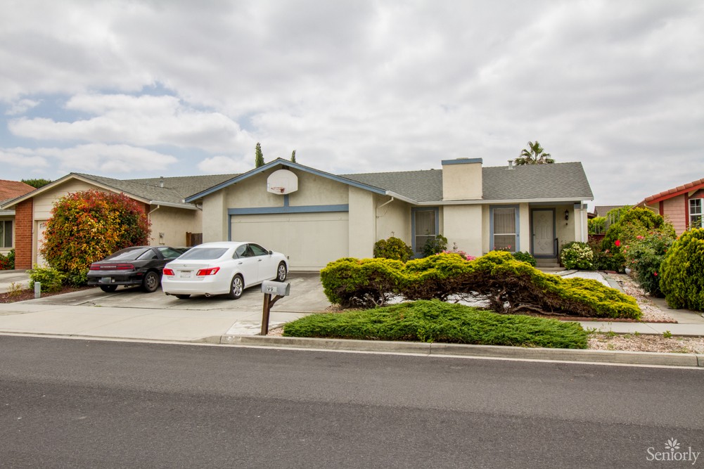 A suburban house with a two-car driveway on a cloudy day.