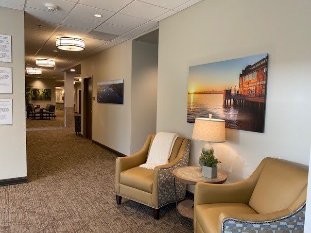 A cozy office lobby with seating and artwork on the walls.
