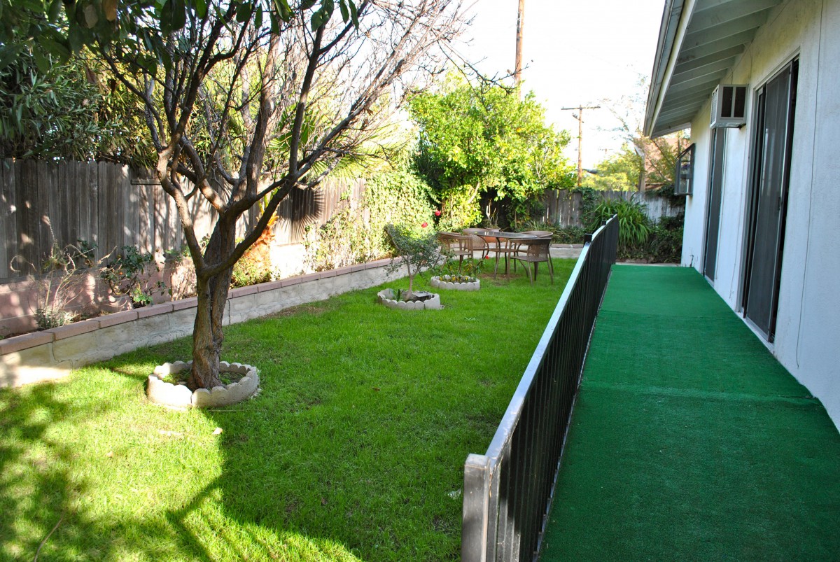 A well-maintained garden with a lush green lawn and trees.