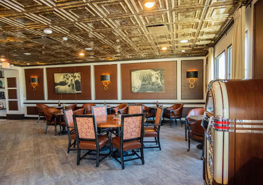 A cozy restaurant interior with decorative wall art and comfortable seating arrangements.