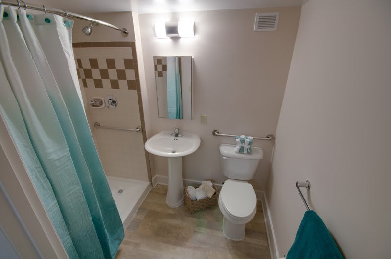 A compact bathroom with a shower, sink, and toilet.