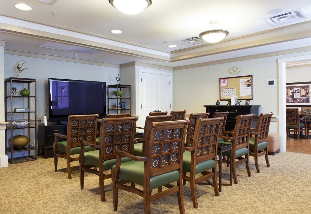 A well-arranged conference room with chairs facing a television screen.