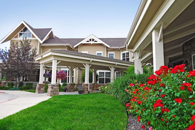 A well-maintained residential building with lush landscaping and vibrant flowers.