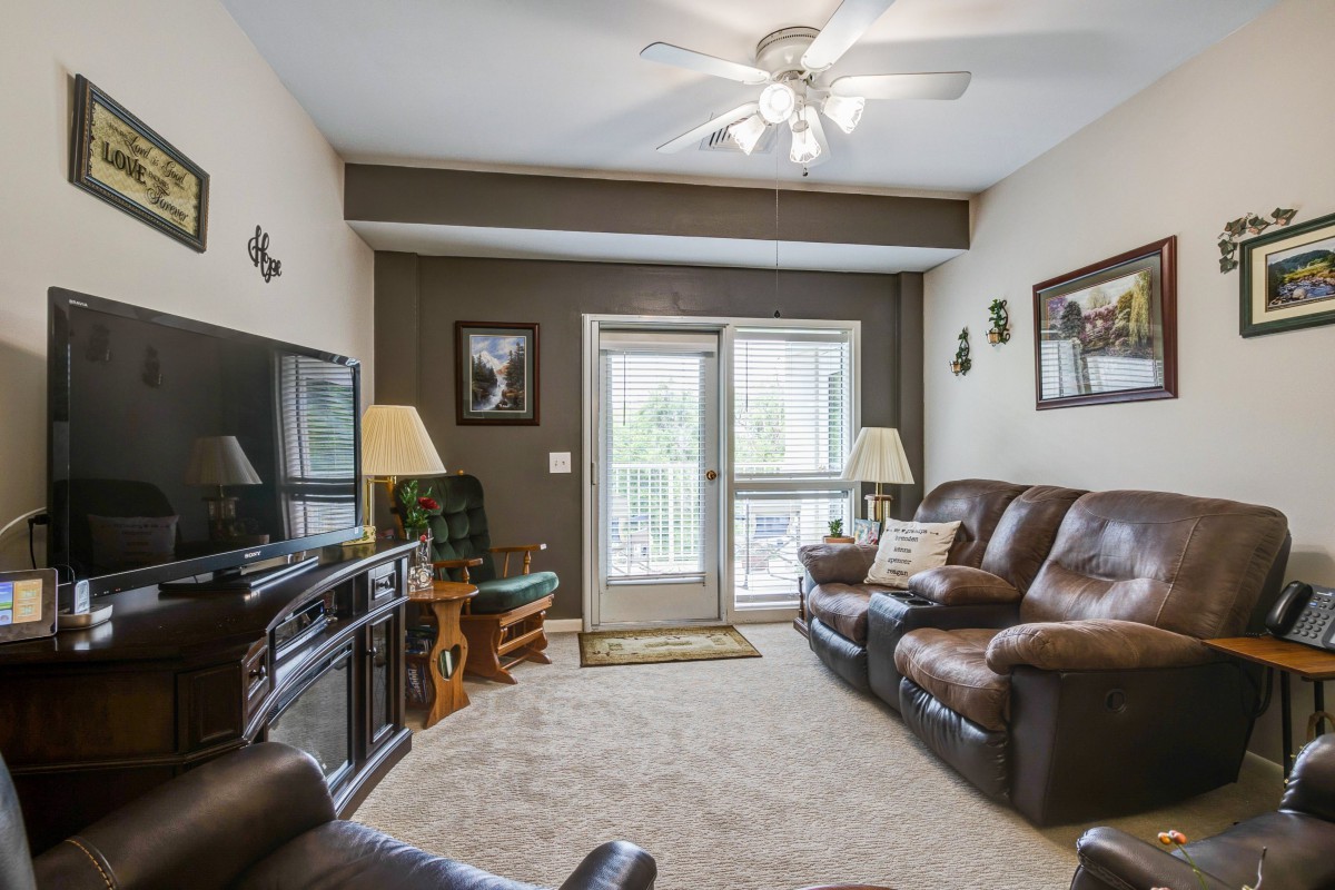 A cozy living room with leather sofas, a large TV, and elegant decor.