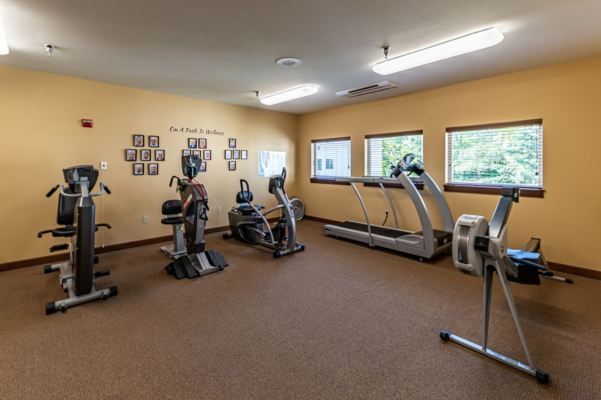A small fitness room with various exercise equipment, including treadmills and stationary bikes.